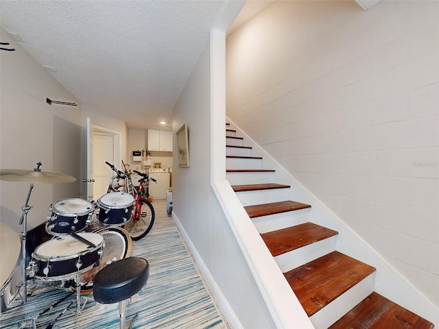 stairs with a textured ceiling