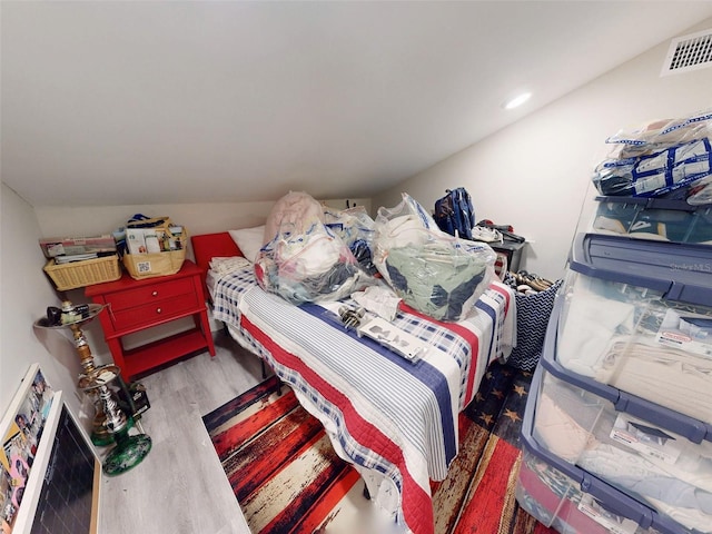 bedroom with hardwood / wood-style flooring and lofted ceiling