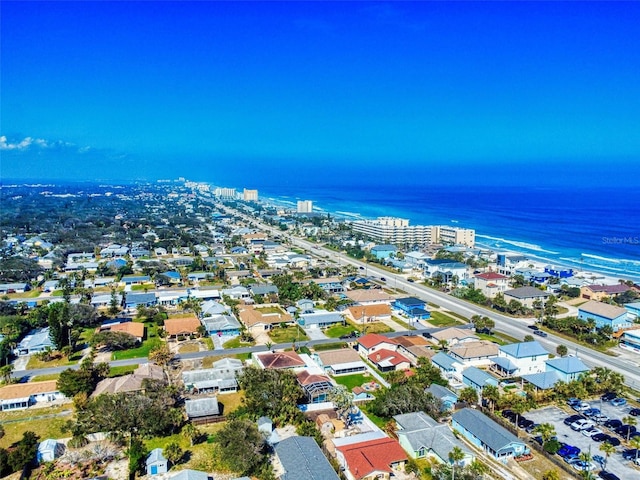 bird's eye view with a water view and a beach view