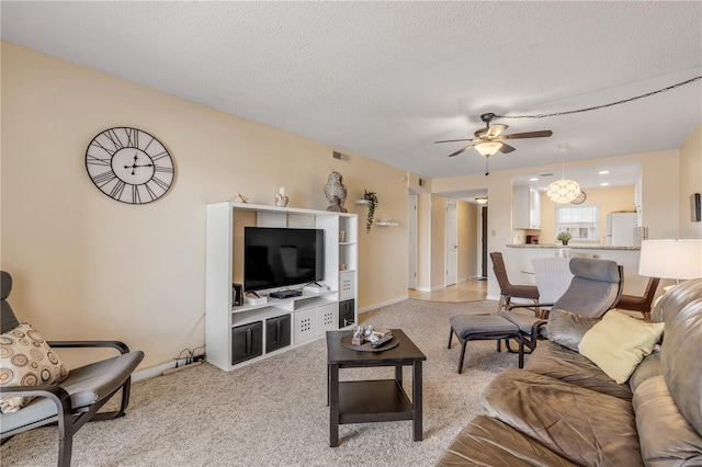 living room with ceiling fan, light carpet, and a textured ceiling