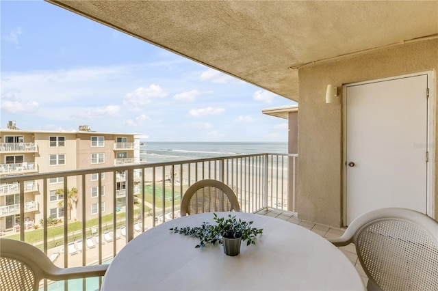 balcony featuring a water view and a view of the beach