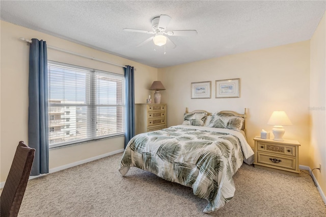 carpeted bedroom featuring ceiling fan and a textured ceiling