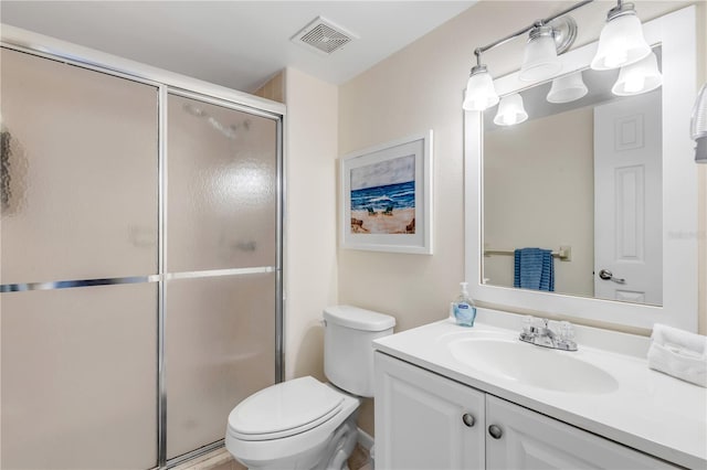 bathroom with an enclosed shower, vanity, and toilet