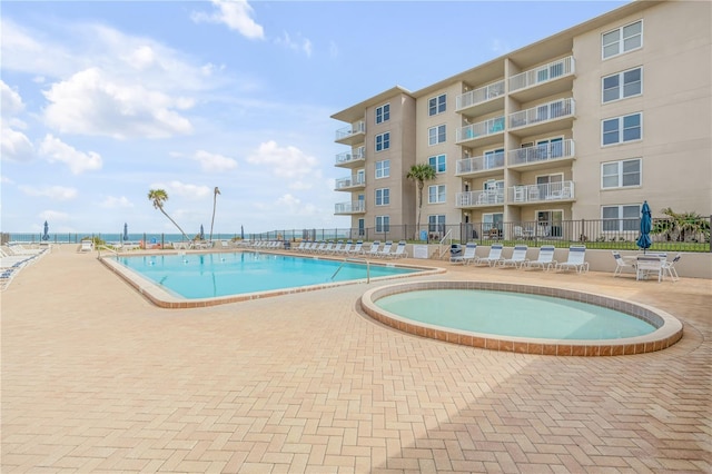 view of pool with a jacuzzi and a patio area