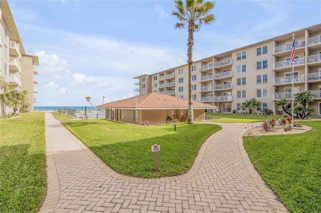 view of home's community featuring a lawn and a water view