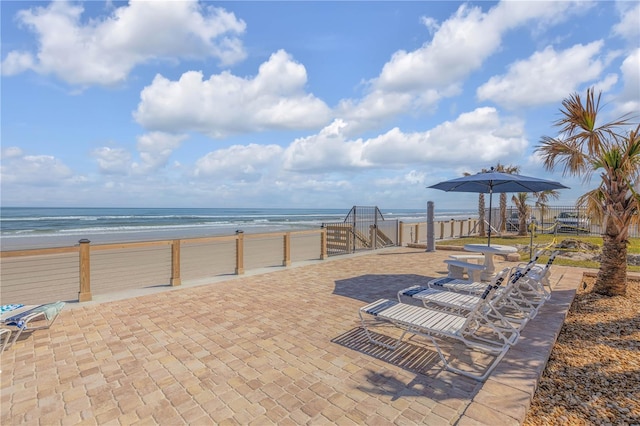 view of patio / terrace featuring a water view and a view of the beach