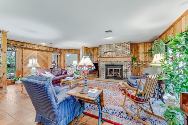 living room with a brick fireplace and wood walls