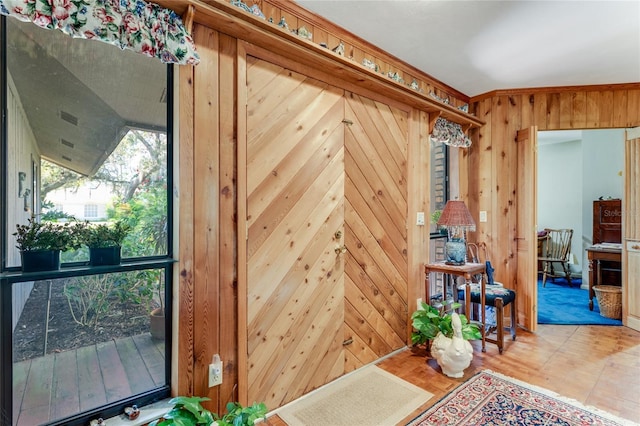 doorway to outside with wood walls