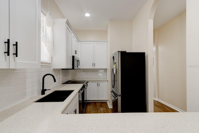 kitchen with dark wood-type flooring, sink, white cabinetry, tasteful backsplash, and stainless steel appliances