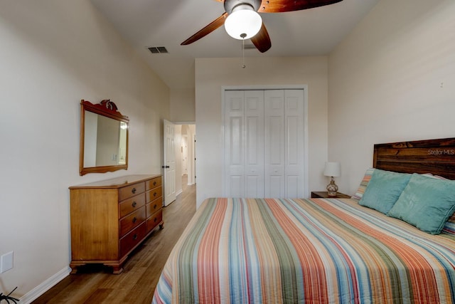 bedroom with ceiling fan, dark hardwood / wood-style flooring, and a closet