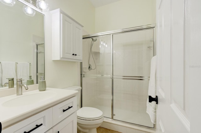 bathroom featuring an enclosed shower, vanity, and toilet