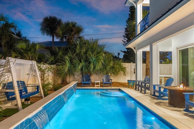 pool at dusk with a fenced in pool, a fenced backyard, and a patio area