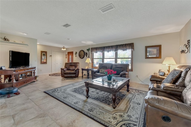 living room with light tile patterned flooring and a textured ceiling