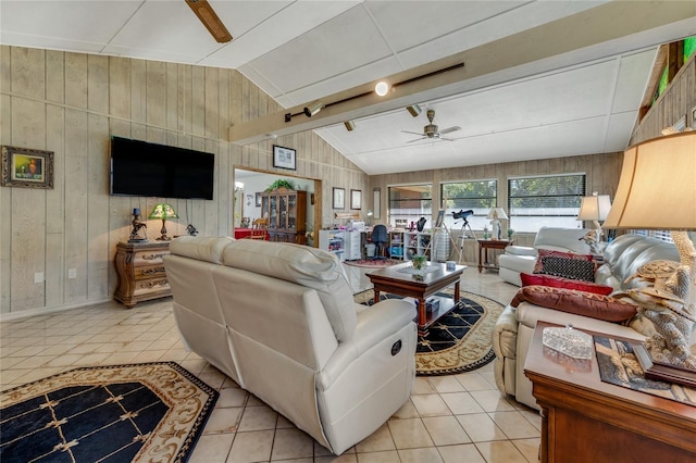 living room with vaulted ceiling, light tile patterned flooring, ceiling fan, and wood walls