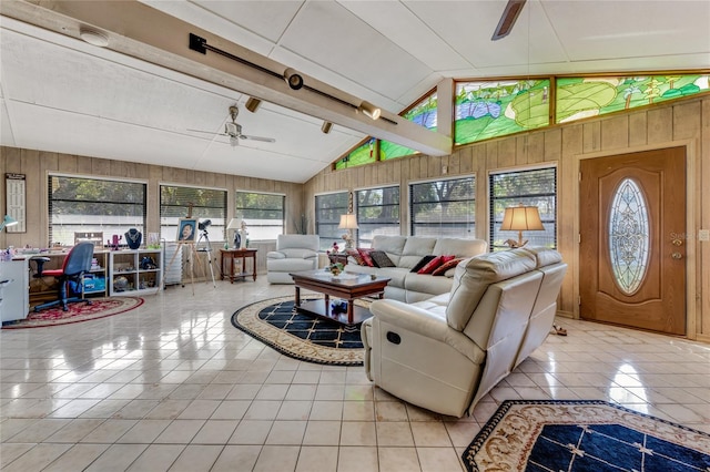 tiled living room featuring ceiling fan, plenty of natural light, vaulted ceiling with beams, and wooden walls