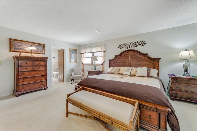 bedroom featuring light colored carpet, ensuite bathroom, and a textured ceiling