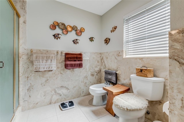 bathroom featuring tile patterned flooring, a bidet, a shower with door, and toilet