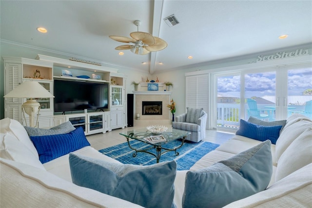 tiled living room with ornamental molding, ceiling fan, and french doors