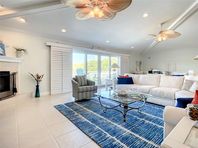 living room with lofted ceiling, ornamental molding, light tile patterned floors, a high end fireplace, and ceiling fan