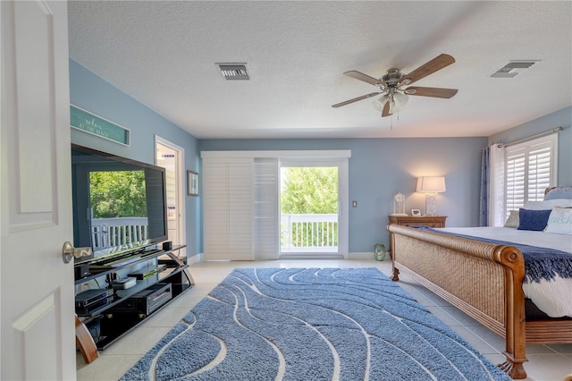 bedroom featuring multiple windows, light tile patterned floors, and access to outside