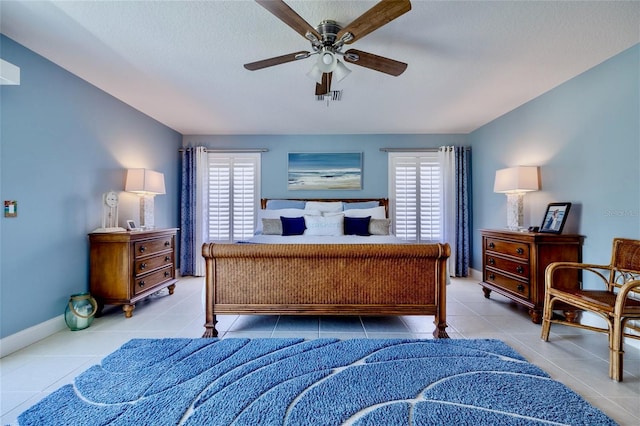 bedroom with multiple windows, light tile patterned floors, vaulted ceiling, and ceiling fan