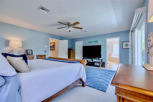 bedroom featuring light tile patterned flooring, connected bathroom, ceiling fan, and a textured ceiling