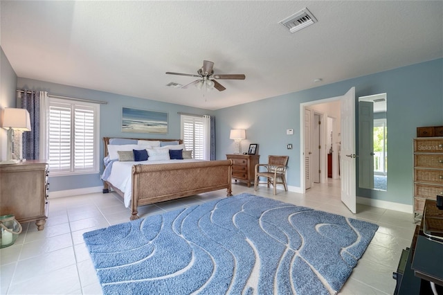 tiled bedroom with ceiling fan and a textured ceiling