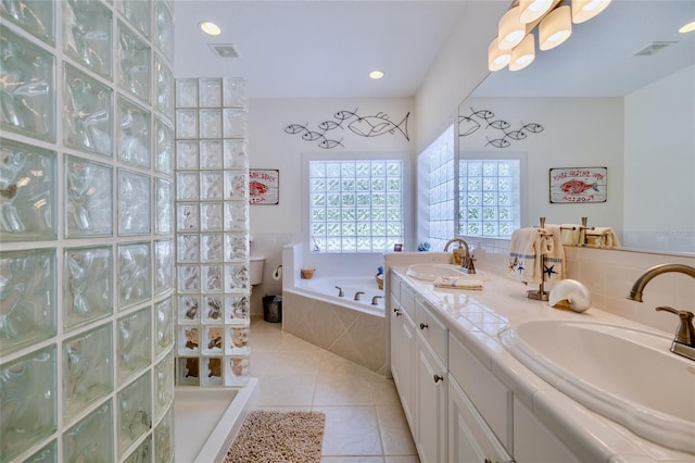 bathroom featuring tile patterned flooring, sink, and tiled tub