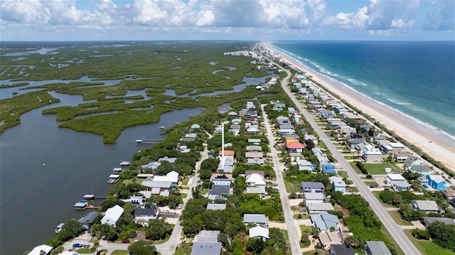 drone / aerial view with a water view and a beach view