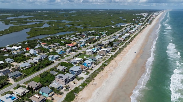 birds eye view of property with a water view and a beach view