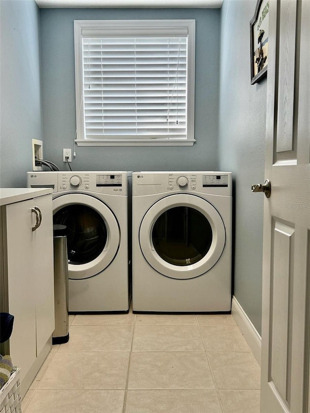 washroom with independent washer and dryer, light tile patterned flooring, laundry area, and plenty of natural light