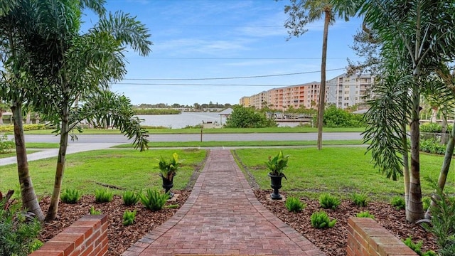 view of property's community with a yard and a water view