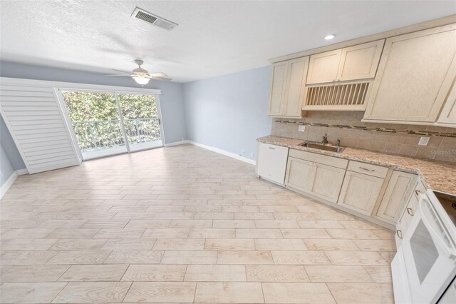 kitchen featuring sink, decorative backsplash, ceiling fan, light stone countertops, and white appliances