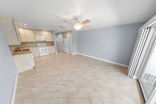 kitchen featuring sink, backsplash, white appliances, ceiling fan, and a textured ceiling