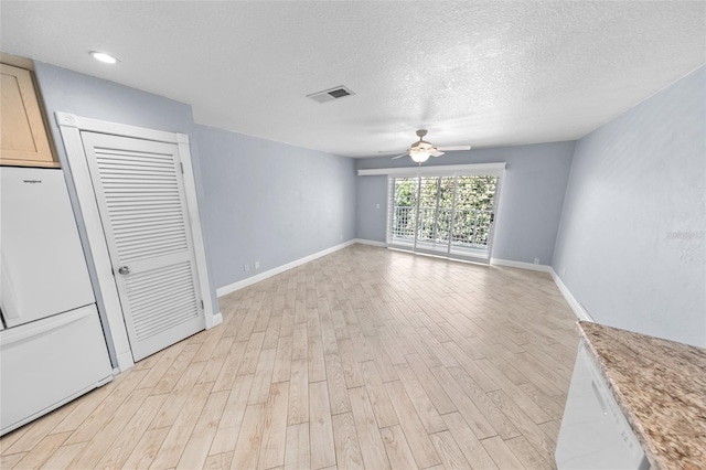 interior space with ceiling fan, a textured ceiling, and light hardwood / wood-style floors