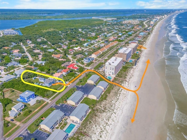 drone / aerial view featuring a water view and a view of the beach