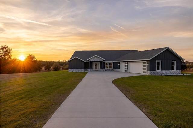 single story home featuring a garage and a yard