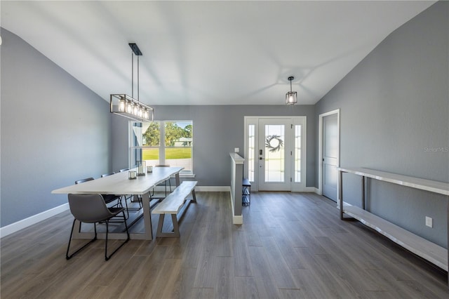 dining room with vaulted ceiling, dark wood-type flooring, and a wealth of natural light