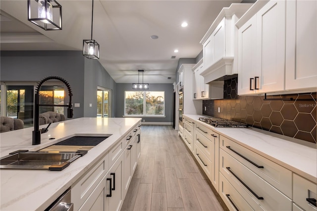 kitchen featuring pendant lighting, sink, and white cabinetry