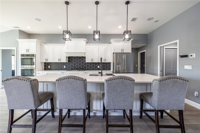 kitchen with pendant lighting, white cabinetry, stainless steel appliances, and sink