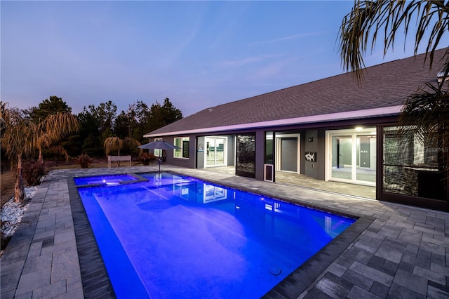 pool at dusk featuring a patio area