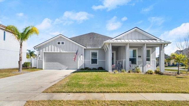 view of front of house with a garage, a front lawn, and covered porch