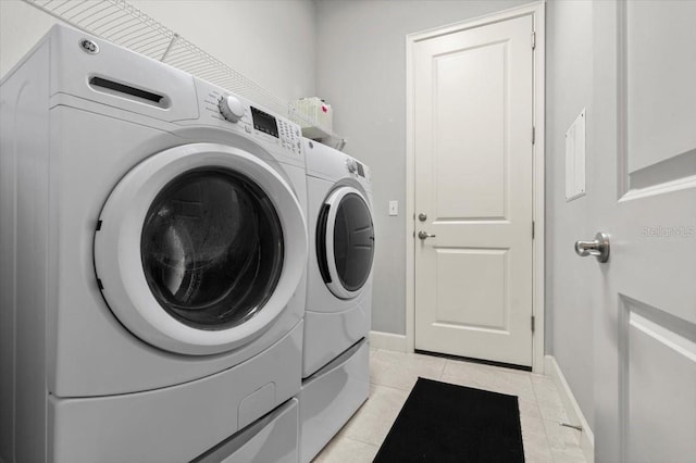 laundry room featuring light tile patterned floors and independent washer and dryer