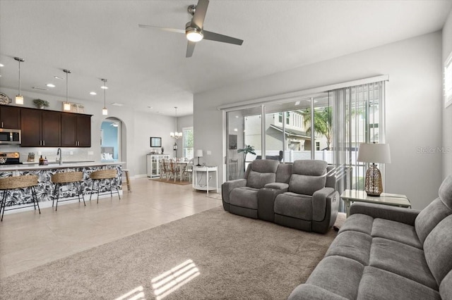 carpeted living room with ceiling fan