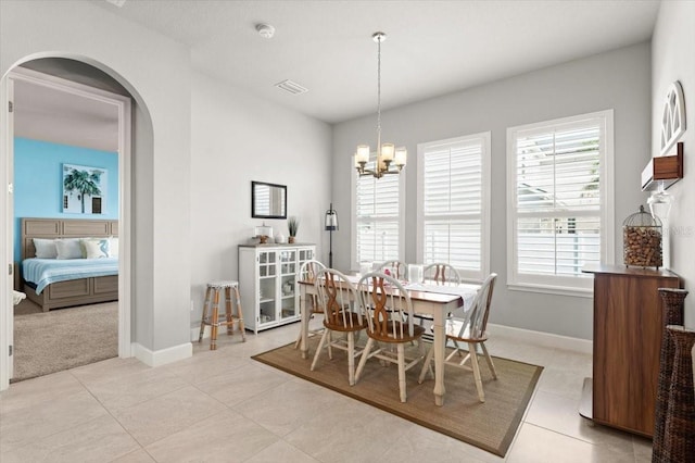 tiled dining room with a chandelier