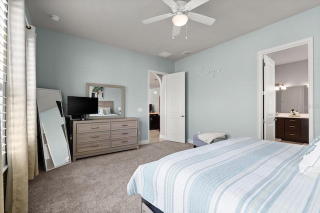 bedroom featuring ceiling fan, light carpet, and ensuite bath