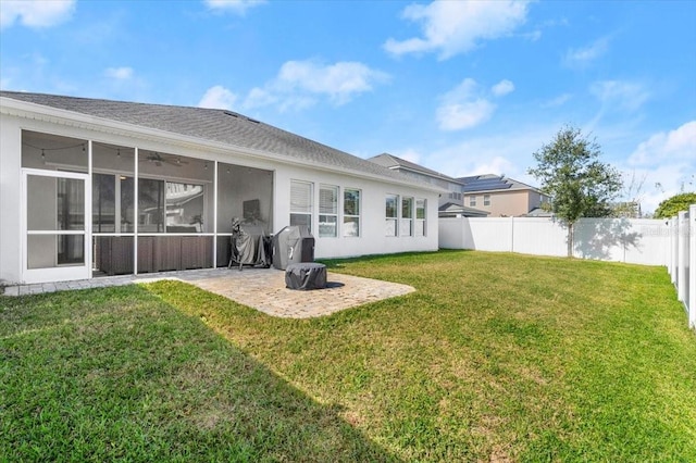 rear view of house with a sunroom, a patio, and a lawn