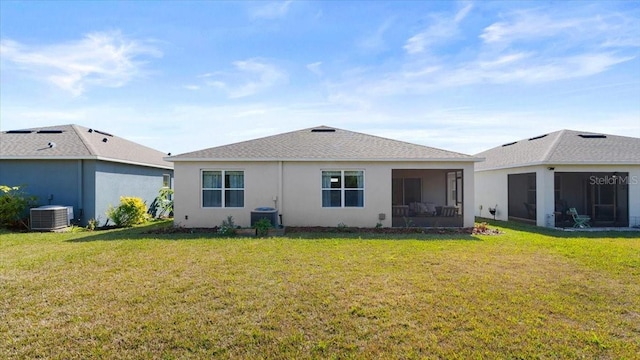 rear view of house featuring a yard, central AC unit, and a sunroom