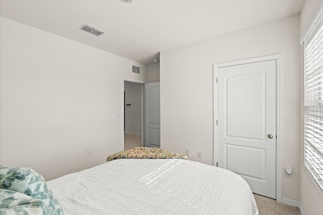 bedroom featuring light colored carpet and multiple windows