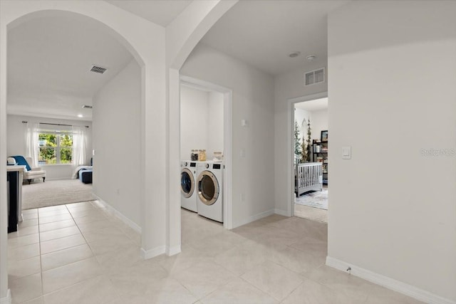 laundry room with light tile patterned floors and washer and clothes dryer